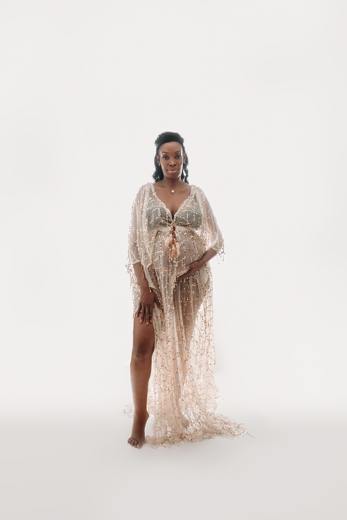Pregnant black woman poses in sparkly dress during maternity photos