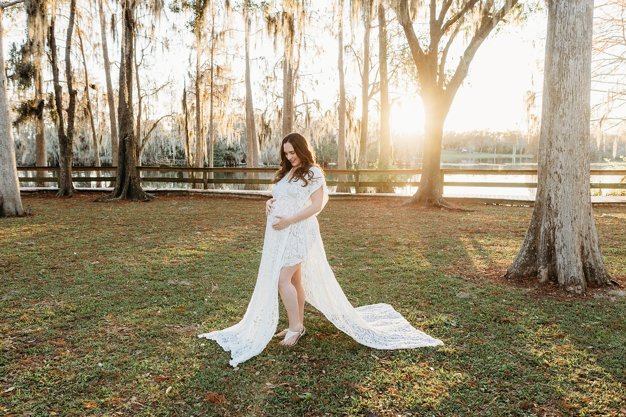pregnant woman gazes down at her pregnant belly during tampa photographer session