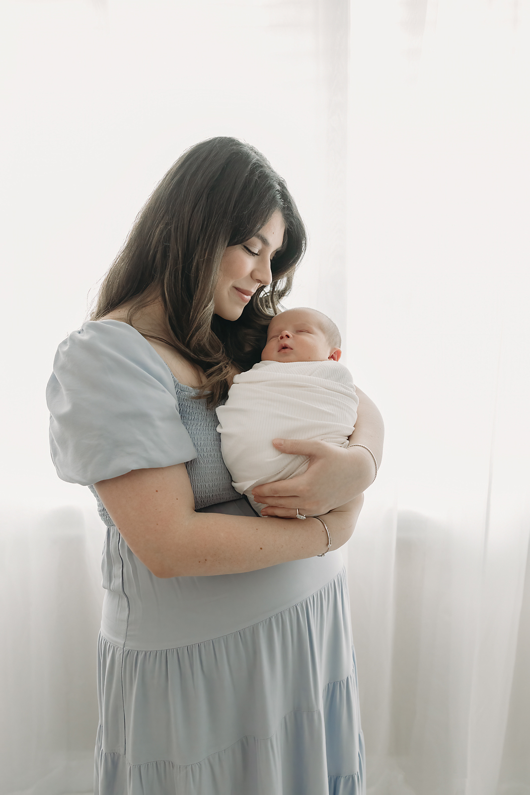 new mother holds baby boy in Tampa newborn photographer session