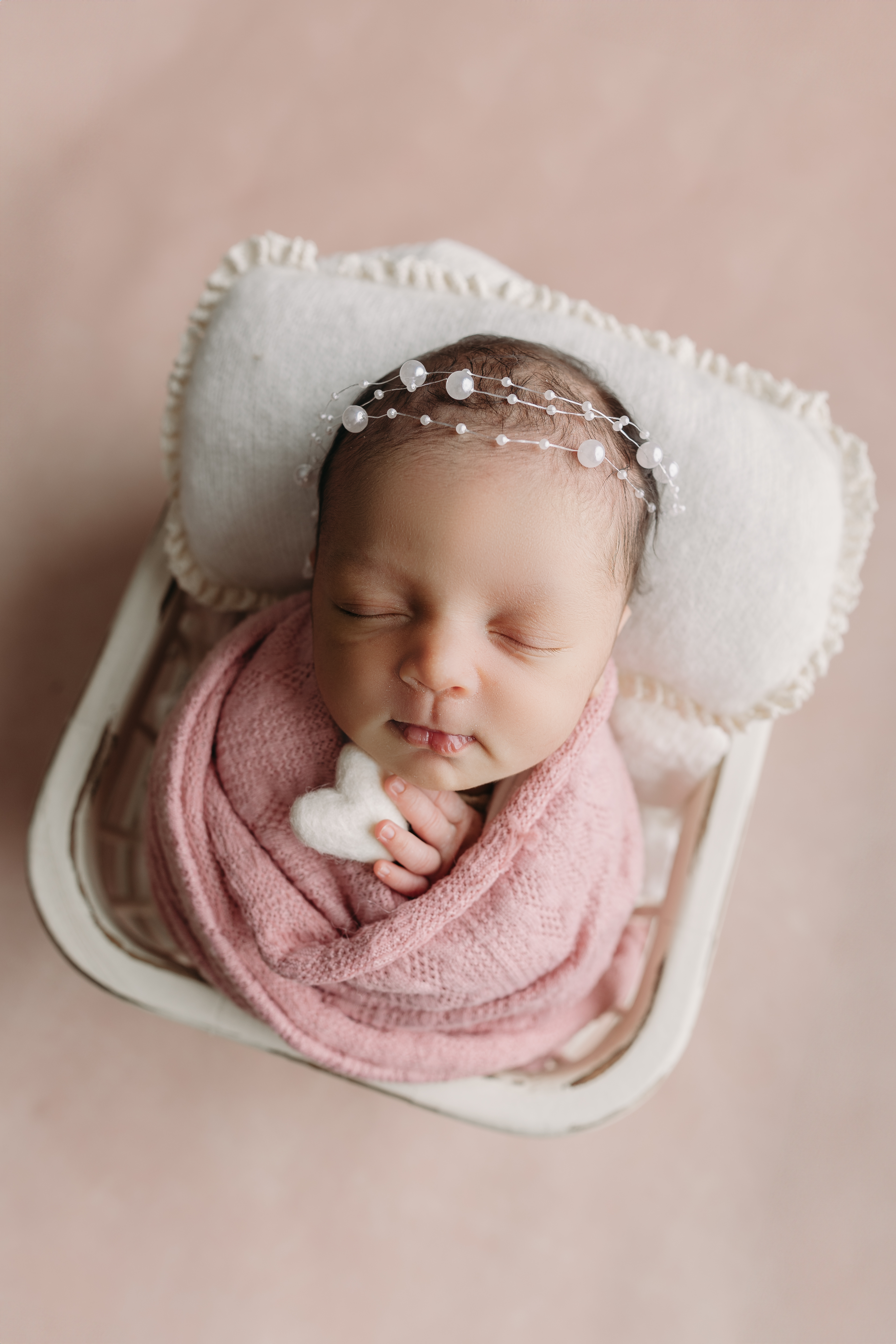 sweet baby girl wrapped in pink during newborn photos in tampa