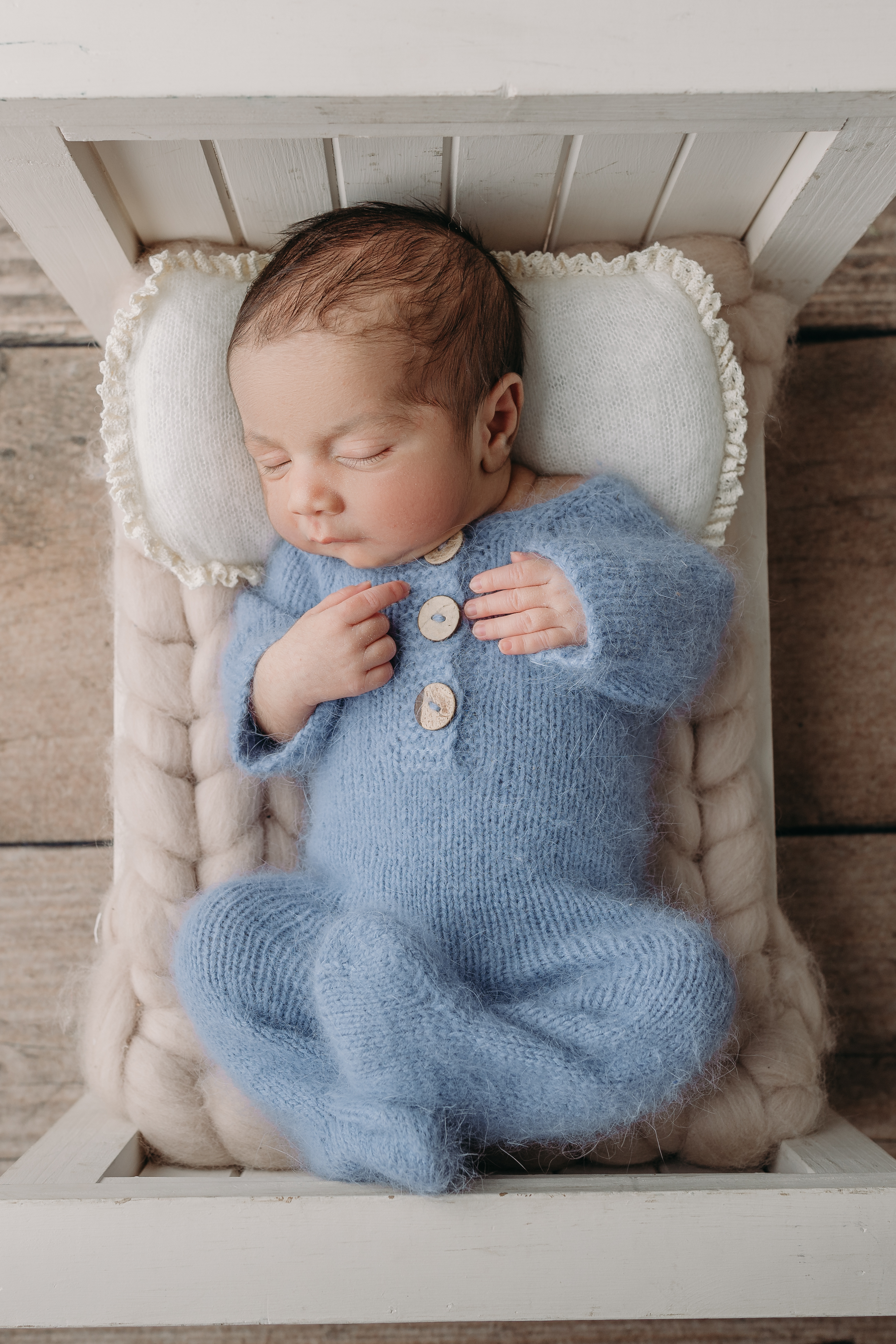 baby boy in blue outfit sleeps