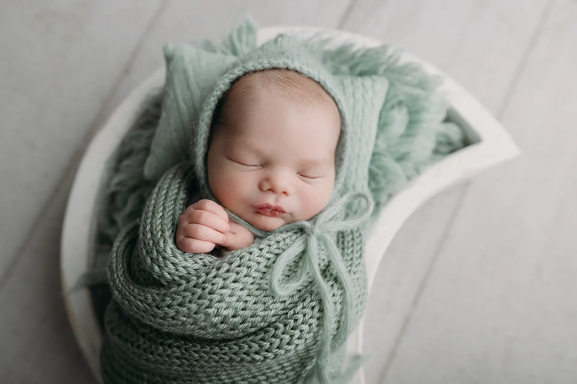 baby boy in moon prop sleeps for newborn photography in Tampa
