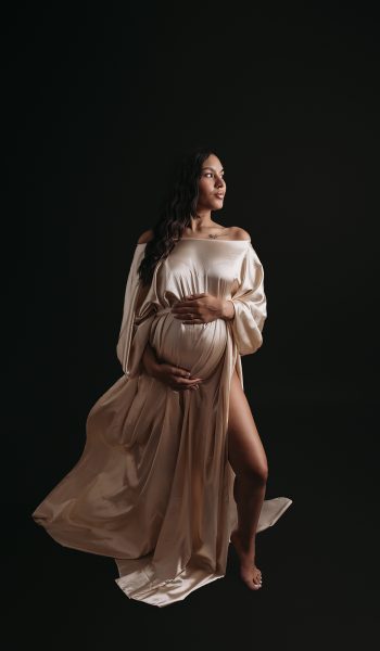 Pregnant mother wearing silky gold dress during tampa maternity photography session