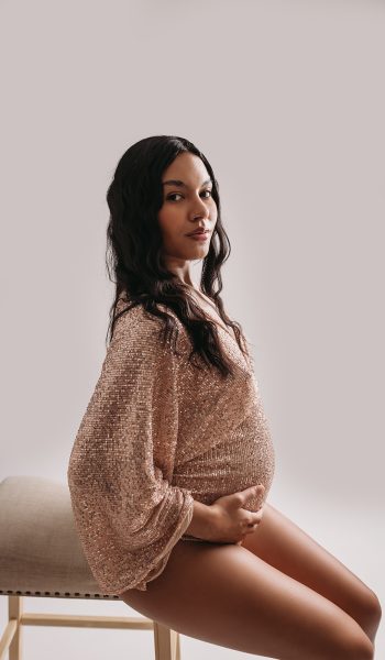 Pregnant woman poses in sparkly gold bodysuit for Tampa maternity photographer
