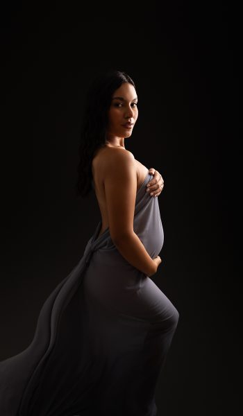 pregnant woman with grey silky fabric poses for her tampa maternity photography session