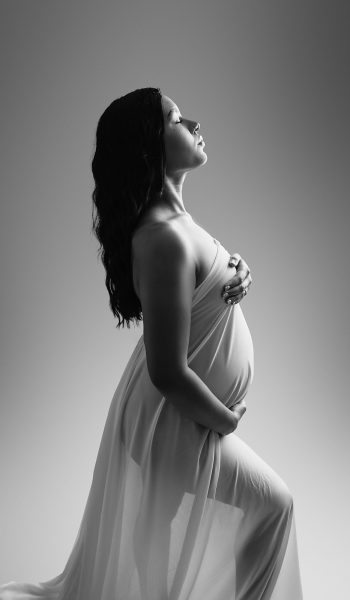 A black and white Tampa maternity portrait showcasing a flowing white dress.