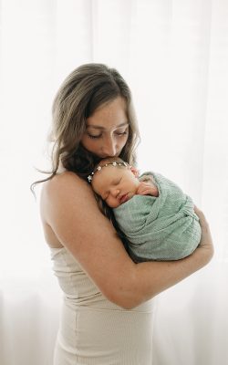 Mother holding swaddled newborn baby