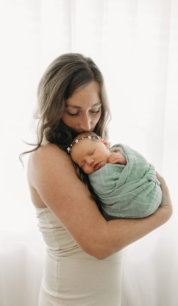 Mother holding swaddled newborn baby