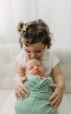 Sister kissing newborn