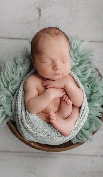 baby boy wrapped in sage green for tampa newborn photography session