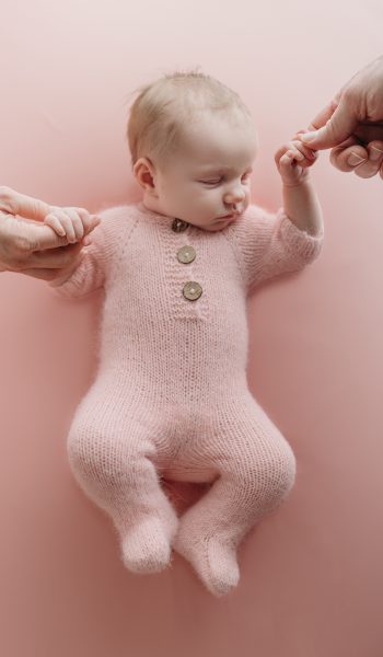 newborn baby girl holding mom and dad's fingers during tampa newborn photographer sesison