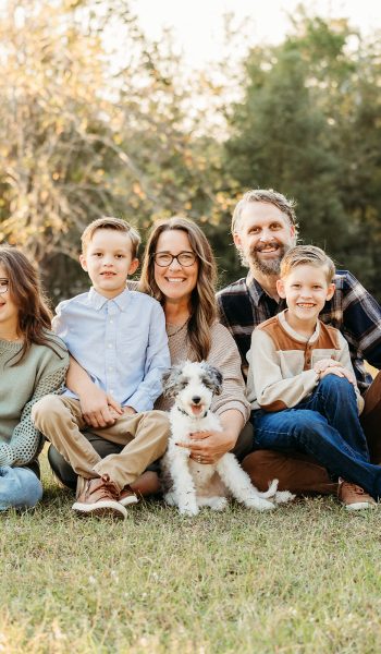 family of five poses outdoors on their family property for tampa family photographer