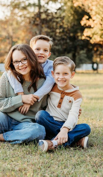 family of five poses outdoors on their family property for tampa family photographer